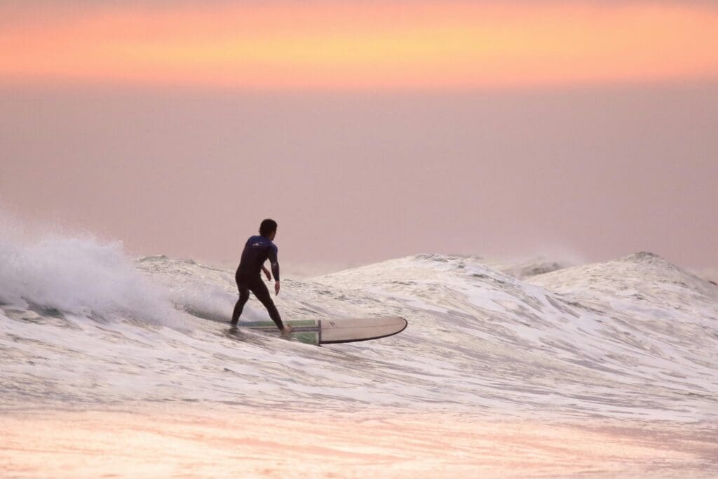 A man surfs in the early morning on one of Hawaii’s beaches.